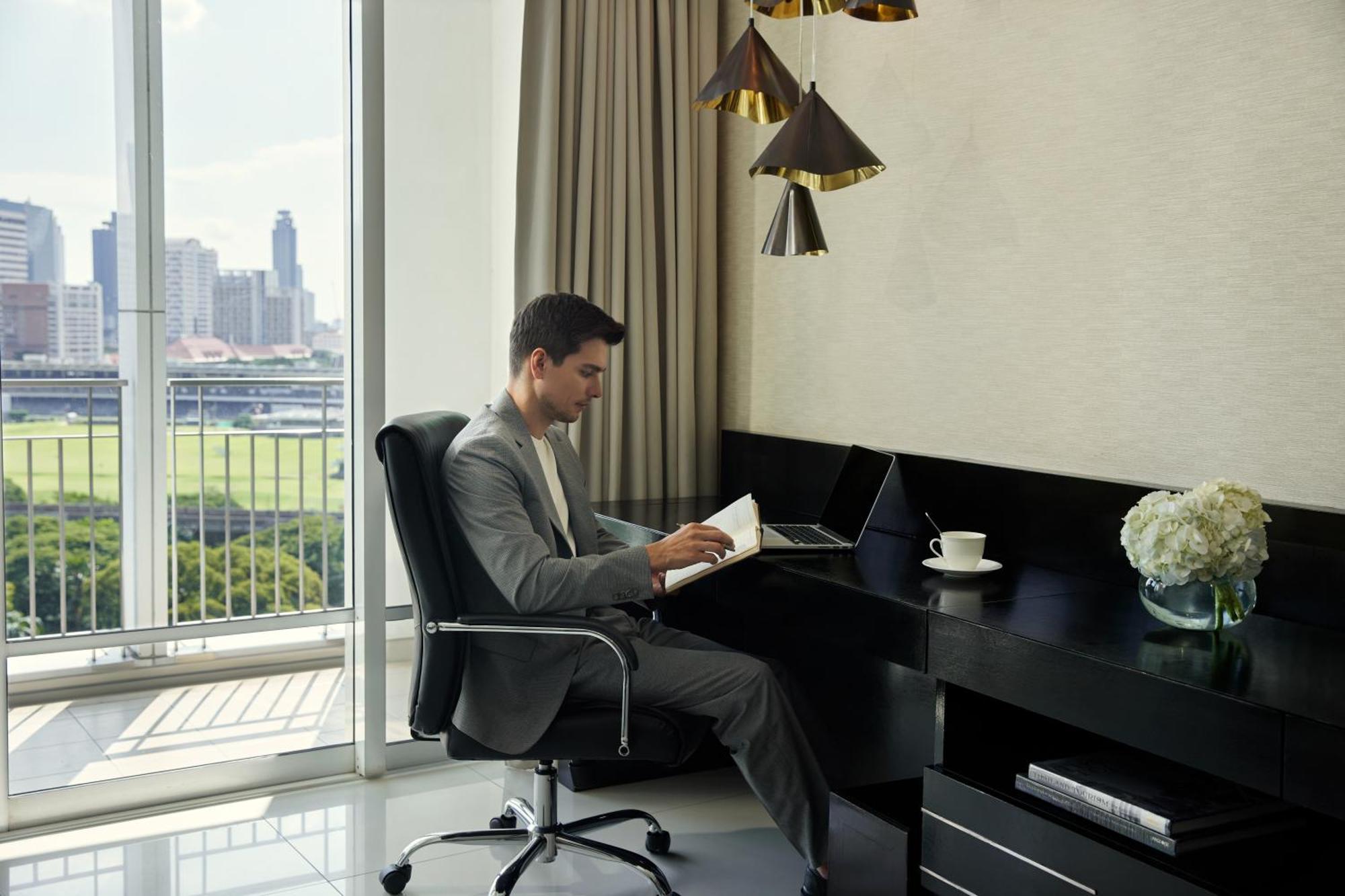 Dusit Suites Hotel Ratchadamri, Бангкок Екстер'єр фото A man working at a desk